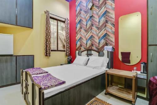 a small room with a bed and a mirror at GRG M S M Residency Puri in Puri