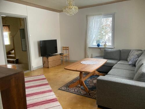 uma sala de estar com um sofá e uma mesa em Daltorp - äldre, charmigt hus på landet em Brunflo