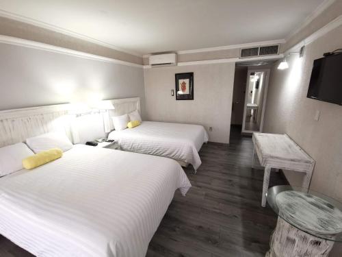 a hotel room with two beds and a table at Paraíso Express in Torreón