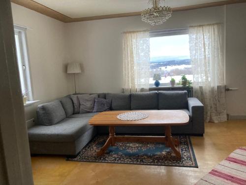 uma sala de estar com um sofá e uma mesa de centro em Daltorp - äldre, charmigt hus på landet em Brunflo