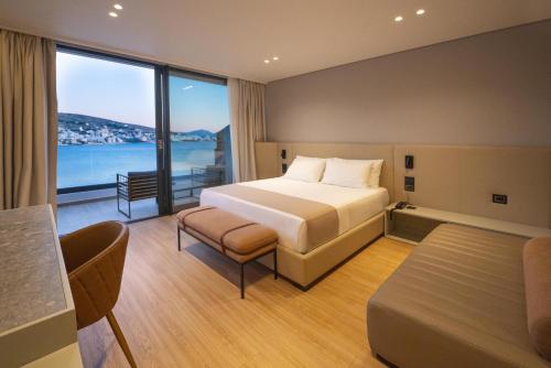 a hotel room with a bed and a view of the ocean at ALYACHT Premium Hotel in Sarandë