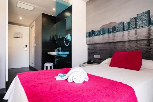 a bedroom with a white bed with a red blanket at Hotel Agua Azul - Adults Only in Benidorm