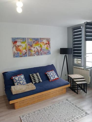- un canapé bleu dans le salon dans l'établissement Les Arcades, T2 en hypercentre, à La Rochelle