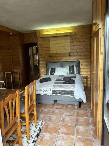 ein Schlafzimmer mit einem Bett in einer Holzhütte in der Unterkunft Grand bec in Brides-les-Bains