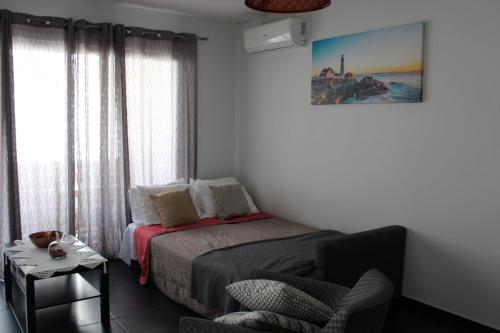 - une chambre avec un lit, une chaise et une fenêtre dans l'établissement Appartement Pinheiro, à Portimão