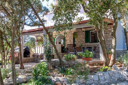 a stone house with a fireplace in a yard at Apartman Mario in Korčula