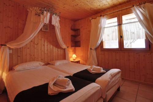 a bedroom with two beds and two windows at Chalet Les Grolets - Ardent in Montriond