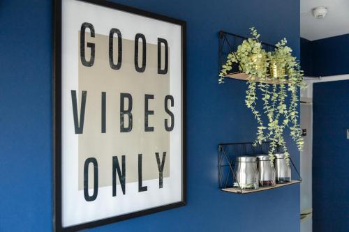 uma parede azul com um sinal que diz boas vibrações apenas em New - Stylish 4 bedroom House, Business & Leisure. Discount on long stays. By Jesswood Properties. em Southend-on-Sea