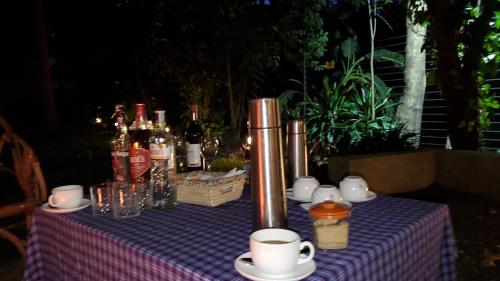 a table with a purple table cloth with bottles and cups at Kizumba House in Arusha