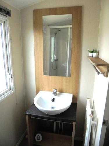 a bathroom with a sink and a mirror at Kingfisher Mistral 8 Berth, Central Heated, Close to site exit FREE WIFI in Ingoldmells
