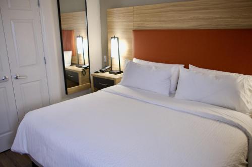 a large white bed in a hotel room at Candlewood Suites Harrisonburg by IHG in Harrisonburg
