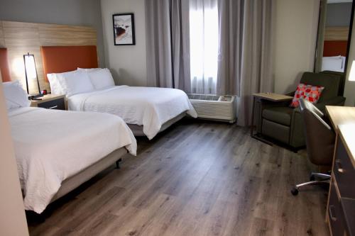 a hotel room with two beds and a window at Candlewood Suites Harrisonburg by IHG in Harrisonburg