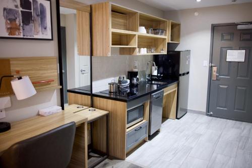 a kitchen with a black counter top and a desk at Candlewood Suites Harrisonburg by IHG in Harrisonburg