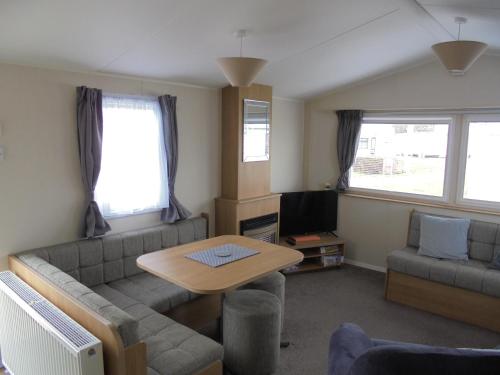 a living room with a couch and a table at Kingfisher Mistral 8 Berth, Central Heated, Close to site exit FREE WIFI in Ingoldmells