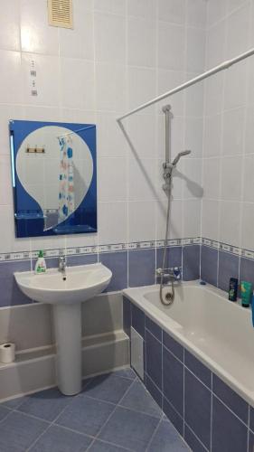 een badkamer met een wastafel en een bad bij Студия в центре in Astana