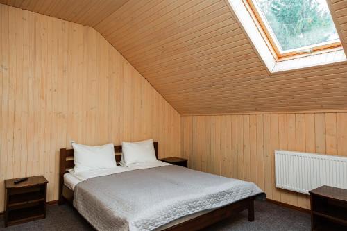 um quarto com uma cama num quarto com uma janela em Мігалі em Dragobrat