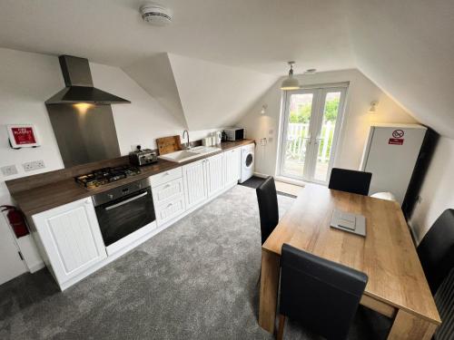 a kitchen with a wooden table and a dining room at Temperance in Freshwater