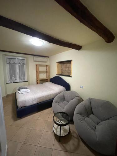 a bedroom with a bed and two chairs and a table at bilocale arredato sestri ponente in Genoa