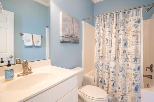 uma casa de banho com um lavatório de WC e uma cortina de chuveiro em Ohana House em Carolina Beach