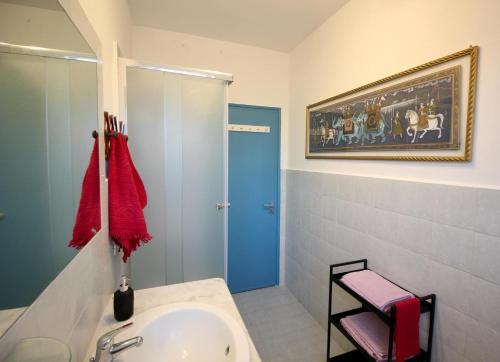 ローマにあるCASA UMBERTOの洗面台付きのバスルーム、壁に絵画