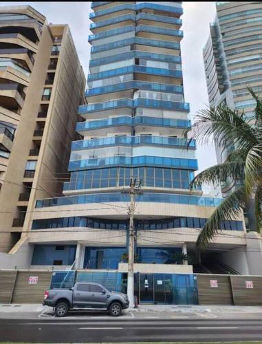 a truck parked in front of a tall building at Prédio Frente Mar Praia da Costa 08 in Vila Velha