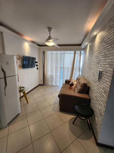 a living room with a couch and a refrigerator at Prédio Frente Mar Praia da Costa 08 in Vila Velha