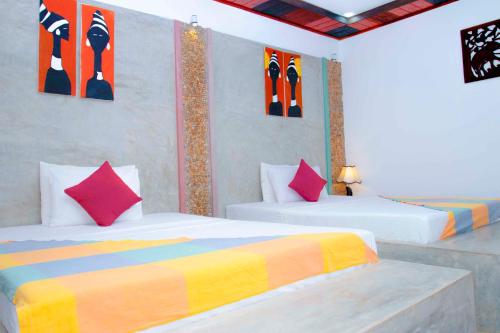 DemanhandiyaにあるMandavilla Airport Transit Hotelのベッドルーム1室(カラフルな枕付きのベッド2台付)