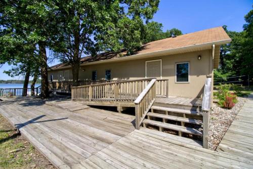 a house with a large wooden deck in front of it at Escape to a Studio Style Hideaway Nature and Lake in Clitherall