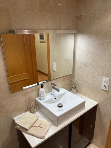 a bathroom with a white sink and a mirror at Ático El Reducto views in Arrecife