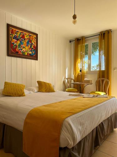 une chambre avec un grand lit avec des oreillers jaunes dans l'établissement Hôtel La Fiancée du Pirate, à Villefranche-sur-Mer