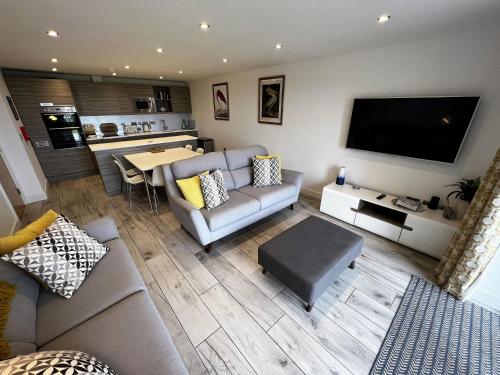 a living room with a couch and a flat screen tv at The Beach Retreat - Pet Friendly in Sandown