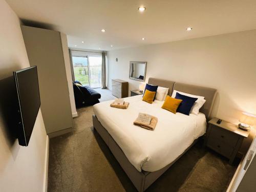 a bedroom with a large bed with yellow and blue pillows at The Beach Retreat in Sandown