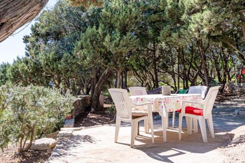 a table and chairs with a table and trees at Apartman Mario in Korčula