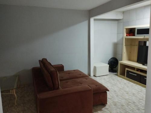 ein Wohnzimmer mit einem Sofa und einem TV in der Unterkunft Casa da Vó Bia in Caparaó Velho