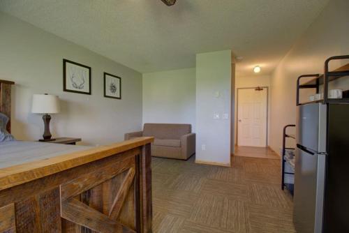 a room with a bed and a couch and a refrigerator at Spitzer Lake Escape to a Studio Style Cottage in Clitherall