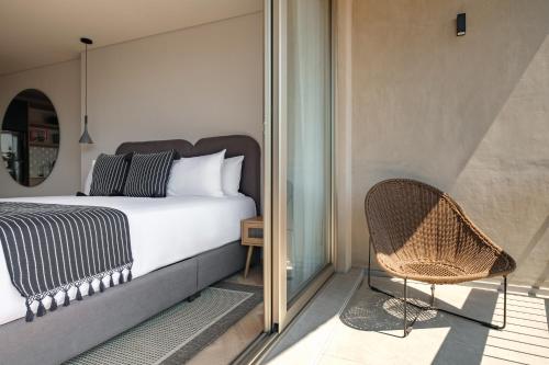 a bedroom with a bed and a chair on a balcony at Casa Cibeles by Lumina in Mexico City