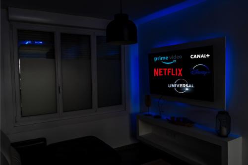 Cette chambre dispose d'une télévision dans une pièce sombre. dans l'établissement Maison de ville de 100 m2, à Amiens