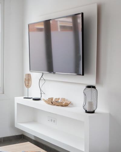 une étagère blanche avec une télévision sur un mur dans l'établissement Maison de ville de 100 m2, à Amiens