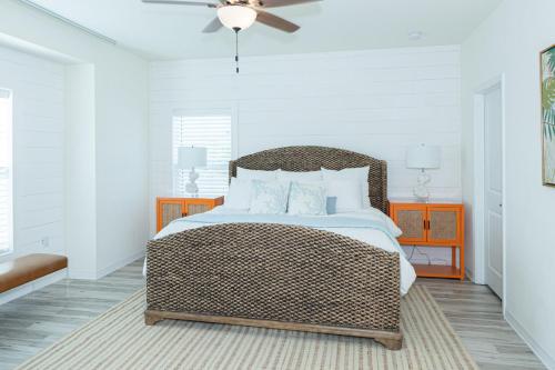 Un dormitorio con una cama de mimbre y un ventilador de techo. en New Listing, Luxury 4bd Steps to Beach Club, en Pensacola