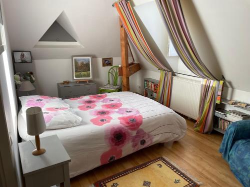 Un dormitorio con una cama con flores rosas. en La Maison du Parc en Saint-Raphaël