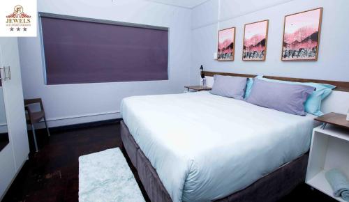 a bedroom with a large bed and a large window at JFT self catering units in East London