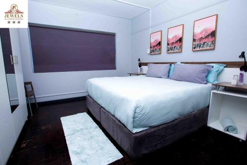 a bedroom with a large bed and a large window at JFT self catering units in East London