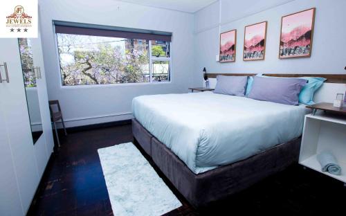 a bedroom with a large bed and a window at JFT self catering units in East London