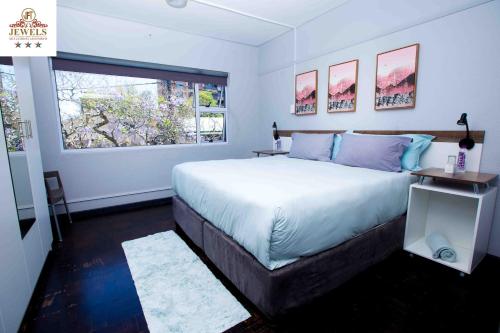 a bedroom with a large bed and a window at JFT self catering units in East London