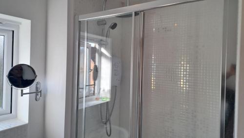 eine Dusche mit Glastür im Bad in der Unterkunft Tropical Sun Homes - Beautiful spacious home in a serene environment with free parking in Manchester