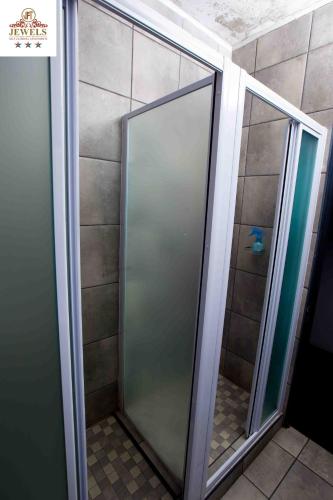 a shower stall with glass doors in a bathroom at JFT self catering units in East London