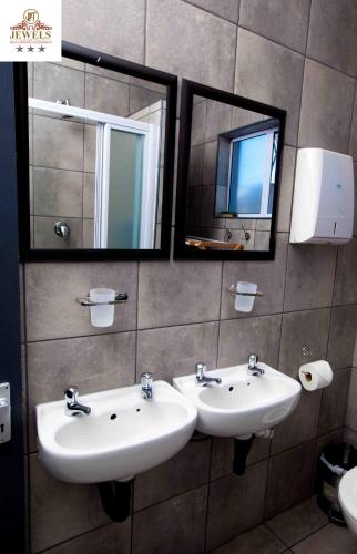a bathroom with two sinks and two mirrors at JFT self catering units in East London