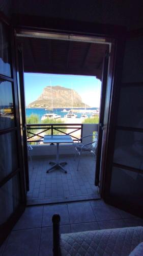 a room with a view of a boat in the water at AGNANTIO in Monemvasia