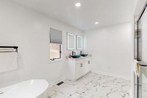 a white bathroom with a tub and a sink at Plum Paradise in Glenora