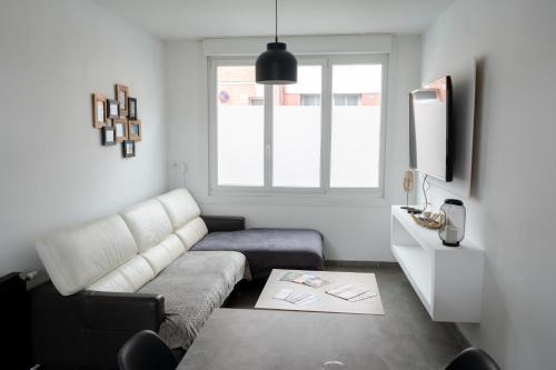 un salon avec un canapé et une télévision dans l'établissement Maison de ville de 100 m2, à Amiens
